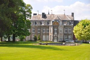 um grande edifício com um relvado verde em frente em Les terrasses de la vallée - Esneux (Liège) em Méry