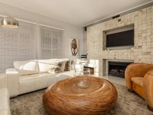 a living room with a white couch and a fireplace at Villa Galazzio in Cape Town