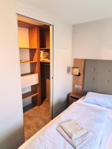 ein kleines Schlafzimmer mit einem Bett und einem Schrank in der Unterkunft Rêve d'été - Camping Belle-Vue 2000 in Berdorf