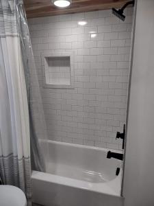 a bathroom with a white tub and a toilet at Tiny Home Big Fun in Knoxville