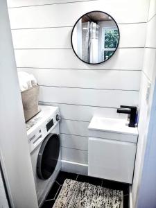uma casa de banho com uma máquina de lavar roupa e um espelho. em Tiny Home Big Fun em Knoxville