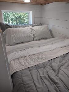 a large bed in a room with a window at Tiny Home Big Fun in Knoxville