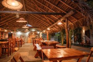un restaurante con mesas de madera y sillas de madera en Pousada Villa Coqueiro, en Luís Correia