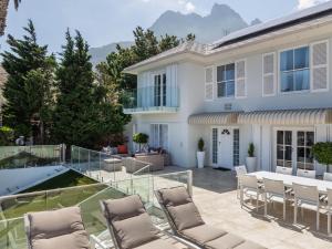 Cette maison dispose d'une terrasse en verre avec des chaises et une table. dans l'établissement Villa Galazzio, au Cap