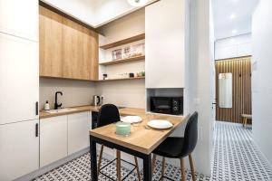 a kitchen with a wooden table and black chairs at Modern 3 Bedrooms Apartment in Budapest