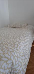 a bed in a bedroom with a white comforter at Appartement entier lumineux in Joué-lès-Tours +9 photos