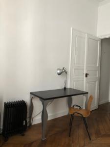 a black desk with a lamp and a chair at Beautiful studio in the heart of Le Marais in Paris