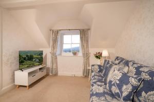 a living room with a blue and white couch and a window at Barnes Fell Apartments in Ambleside