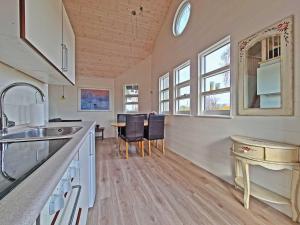 a kitchen with a sink and a table with chairs at Nysted Strand Camping & Cottages in Nysted