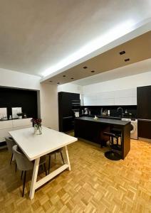 Il comprend un salon avec une table et une cuisine. dans l'établissement ECRIN AU COEUR DE PARIS PRES DU JARDIN DU LUXEMBOURG, à Paris