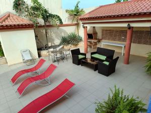 a patio with red and black chairs and tables at Casa Miami in Tarrafal