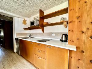 博爾米奧的住宿－Chalet Bormino 6，一个带木制橱柜和水槽的厨房
