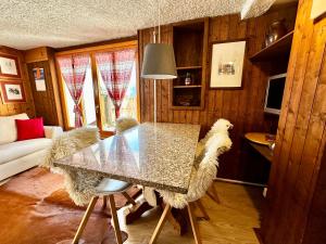a dining room with a table and some chairs at Chalet Bormino 6 in Bormio +4 photos