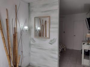 un pasillo con un espejo en una pared blanca en OLIVO&ACACIA en Rosario