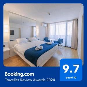 een hotelkamer met een bed met een blauwe deken bij Orbi City in Batoemi