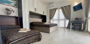 pokój hotelowy z 2 łóżkami i stołem w obiekcie Home 105 Salento w mieście Galatone