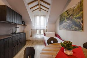 a kitchen with a table and a room with a bed at Granduca Mountain Wellness Apartments Campigna in Campigna