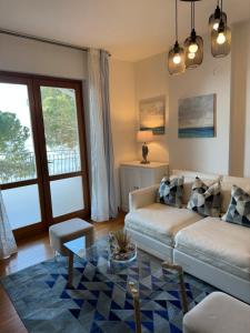 uma sala de estar com um sofá e uma mesa de vidro em Apartment mit Meerblick am Strand Costa Azzura em Grado