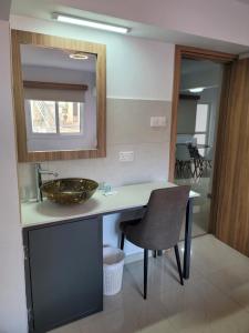 a bathroom with a counter with a sink and a chair at Palm Sea Suite 17 in Larnaka +14 photos