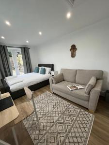sala de estar con sofá y cama en Swan Lake Lodge & free parking, en Cardiff