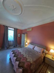 1 dormitorio con 1 cama grande y paredes rojas en Suite Rose, en Camerano
