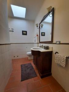 W łazience znajduje się umywalka, lustro i toaleta. w obiekcie Suite Rose w mieście Camerano