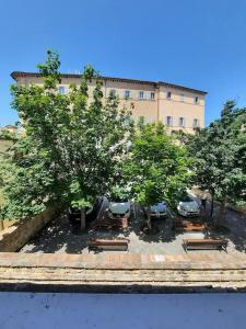 grupa drzew i ławek przed budynkiem w obiekcie Suite Rose w mieście Camerano