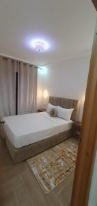 a bedroom with a large white bed with a rug at Hout founty in Agadir