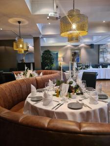 een eetkamer met een tafel met witte tafellakens bij Brook Lane Hotel in Kenmare