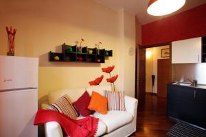 un soggiorno con divano bianco e cuscini colorati di Le Petite Maison ad Andria