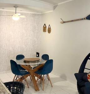 a dining room with a table and blue chairs at Guarujá Flat in Guarujá