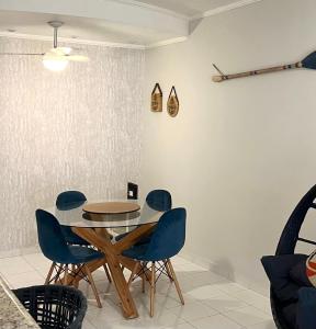 uma sala de jantar com uma mesa e cadeiras azuis em Guarujá Flat no Guarujá