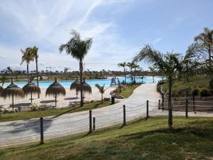 een pad naast een strand met palmbomen bij Villa Lucia at Santa Rosalia Lake & Life Resort in Los Alcázares