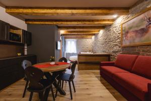 a living room with a red couch and a table at Granduca Mountain Wellness Apartments Campigna in Campigna