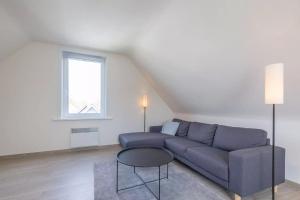 uma sala de estar com um sofá azul e uma mesa em Vakantiehuis Belle em Nieuwpoort
