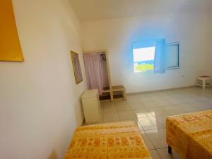 Habitación con 2 camas y ventana en Casa Vacanze Sofimar con Trullo, en Leuca