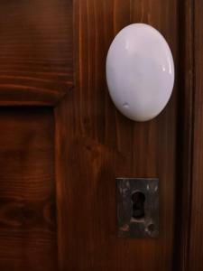 a white orb hanging on a wooden door at Rachel's House in Altamura