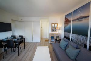 a living room with a couch and a dining room at L'appartement Lafayette in Annecy