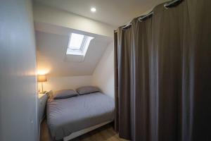 a small bedroom with a bed and a window at L'appartement Lafayette in Annecy