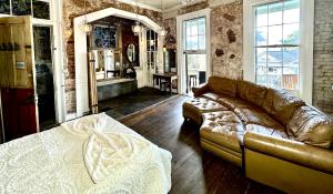 a living room with a leather couch and a mirror at Fleur De Lis Mansion in New Orleans