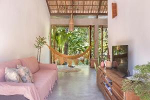 a living room with a couch and a hammock at Casa Canoa - Praia de Algodões in Marau