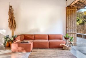 a brown couch in a living room with plants at Casa Canoa - Praia de Algodões in Marau