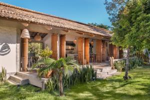 uma casa com um alpendre e um quintal em Casa Canoa - Praia de Algodões em Maraú