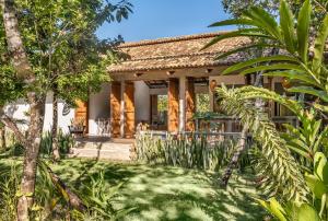 uma villa com um jardim e um resort em Casa Canoa - Praia de Algodões em Maraú