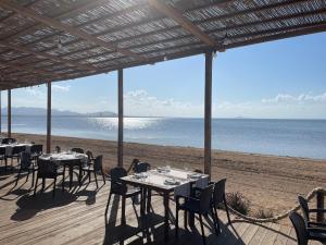 un restaurante en la playa con mesas y sillas en Arona 2 - Casa Menor, en Mar de Cristal