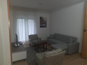 ein Wohnzimmer mit einem Sofa und einem Tisch in der Unterkunft Spazioso Appartamento in casa singola Padova con giardino in Padua