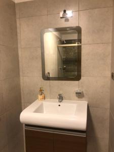 y baño con lavabo blanco y espejo. en Llajtamento 3, en Cochabamba