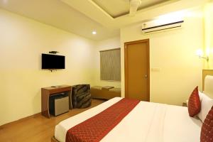a hotel room with a bed and a flat screen tv at HOTEL AIRPORT PALACE in New Delhi