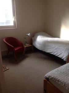 a bedroom with two beds and a chair and a window at 2 bedrooms in the sky ! in Neuilly-sur-Seine