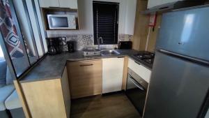 a kitchen with a stainless steel refrigerator and a sink at MOBILE HOME FOR YOU in Canet-en-Roussillon